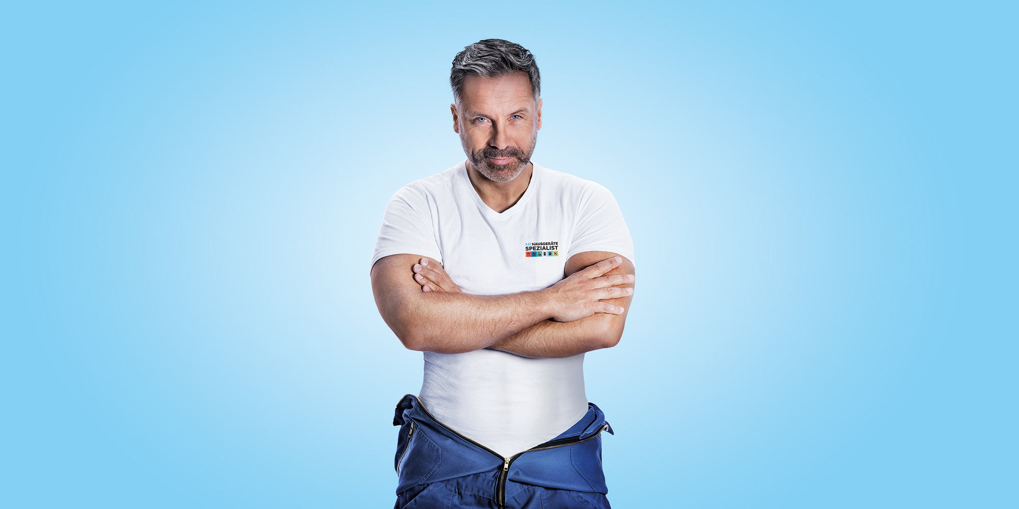 Service-Techniker im Blaumann mit verschränkten Armen