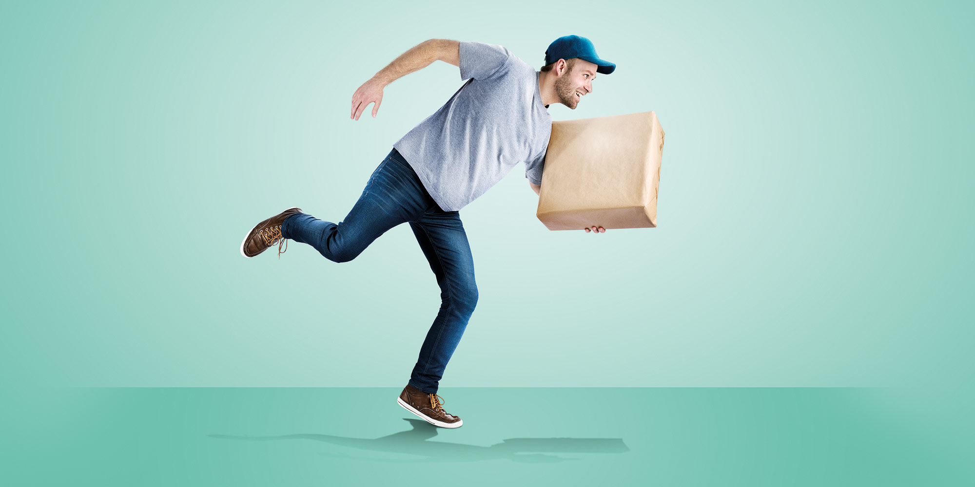 Lieferbote im Laufschritt mit Paket in der Hand